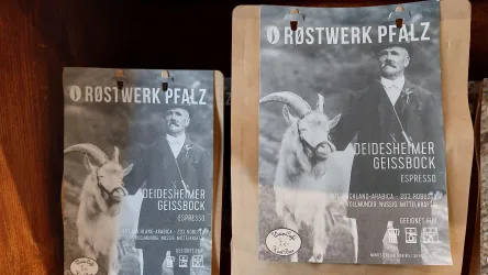 Zwei Kaffeetüten mit nostalgischem Design sind zu sehen. Eine Tüte zeigt einen Mann neben einem Ziegenbock und trägt die Aufschrift "Deidesheimer Geissbock Espresso".