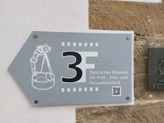 Ein Wegweiser zum Deutschen Museum für Foto-, Film- und Fernsehtechnik. Der Hinweis zeigt die Etage 3F an.