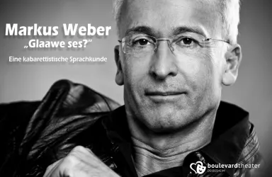 Ein Porträt eines Mannes mit kurzer, grauer Haarfrisur und einer Brille. Er trägt eine schwarze Jacke und schaut direkt in die Kamera.