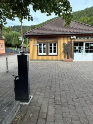 Hier ist das Touristinfobüro am Kuckucksbahnhof, bzw. das Besucherinformationszentrum "Flößerei u. Trift" in Elmstein zu sehen. Im Vordergrund ist die schwarze Fahrrad-Reparatursäule zu erkennen.