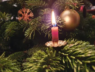 Kerze am geschmückten Weihnachtsbaum