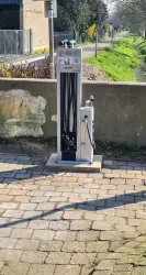 Eine Station zur Wartung von Fahrrädern steht an einem Gehweg. Sie bietet verschiedene Werkzeuge und Möglichkeiten zur Reparatur.