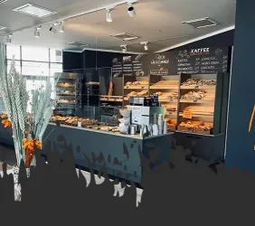 Ein modernes Café mit einer Auswahl an frischen Backwaren und Kaffee. Die Einrichtung ist freundlich und einladend, mit dekorativen Blumen.