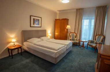 Doppelbett mit Schrank und einer Sitzgruppe mit 2 Stühlen 