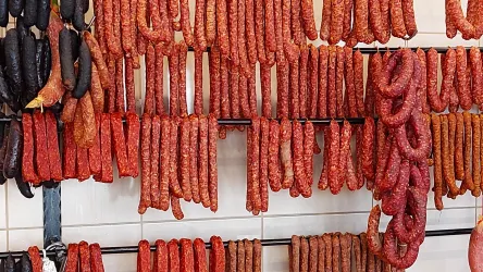 Eine große Auswahl an Wurstwaren hängt an einer Wand. Die Wurst ist in verschiedenen Farben und Formen angeordnet.