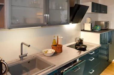 Eine moderne Küche mit grauen Schränken und einer stilvollen Arbeitsfläche. Der Raum ist gut beleuchtet und bietet eine angenehme Atmosphäre.