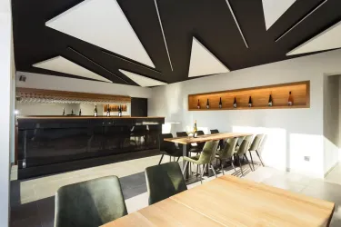 Ein stilvolles Restaurant mit moderner Einrichtung und einer langen Bar. Die Wände sind in hellen Tönen gehalten und es gibt bequeme Sitzmöglichkeiten.