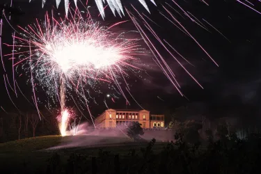 Ein beeindruckendes Feuerwerk erleuchtet den Nachthimmel über der Villa Ludwigshöhe in Edenkoben. Die bunten Funken reflektieren die festliche Atmosphäre.