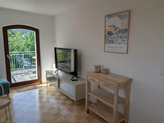 Der Fernseher im Wohn- und Esszimmer neben der Balkontür