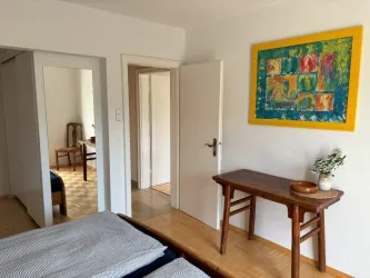 Schlafzimmer mit begehbarem Kleiderschrank und großem Spiegel