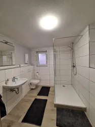Badezimmer mit Waschbecken und Dusche