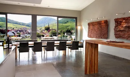Moderne Weinbar mit Blick auf malerische Weinberge. Große Fenster bieten eine helle und einladende Atmosphäre.