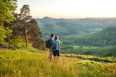 Wanderpärchen bei Lichtung in Hanglage mit Ausblick auf Pfälzerwald