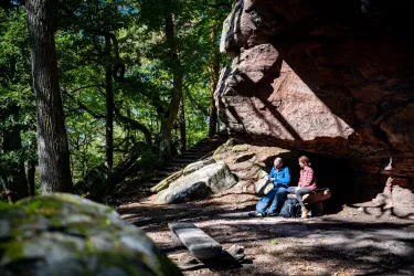 Wanderer bei der Rast am Heidenfels im Pfälzerwald