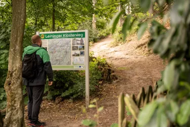 Wanderer bei der Infotafel am Startpunkt des Leininger Klosterwegs