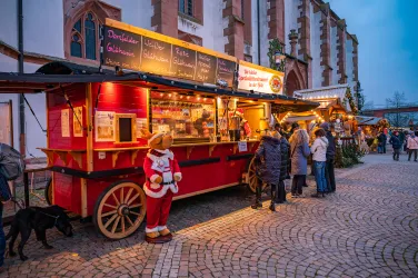 Weihnachtlich geschmückte Buden auf dem Christkindelmarkt in Kandel vor der Kirche.
