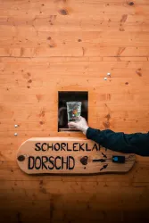 Die Schorleklapp in Bad Dürkheim. Auf der hölzernen Theke steht - Dorschd und ein Pfeil und daneben ist eine Klingel.