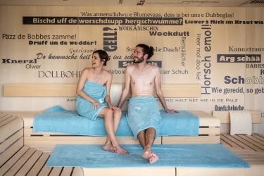 Zwei Personen sitzen in der Babbelsauna im Salinarium Bad Dürkheim Therme und unterhalten sich.