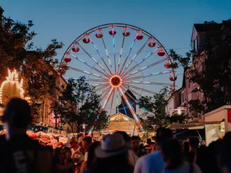 Riesenrad und Feiermeile am Abend beim Strohhutfest in Frankenthal