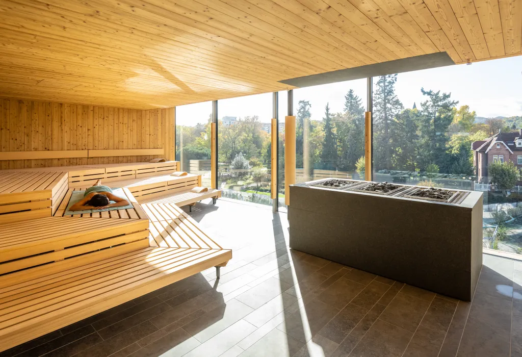 Eine Person liegt auf einem Handtuch in der Panoramasauna der Salinarium Bad Dürkheim Therme.