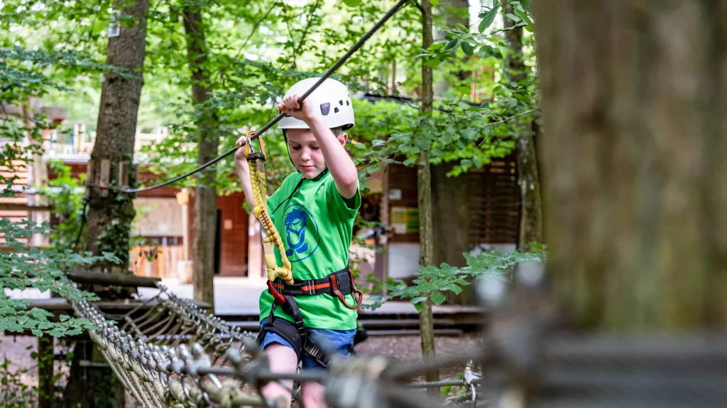 Ein Kind klettert entlang eines Parcours im Kletterpark in Kandel.