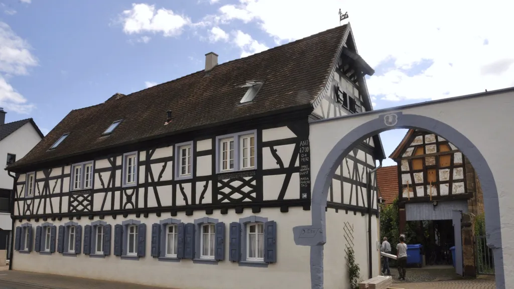 Ein Fachwerkhaus mit einem schönen blauen Bogentor in Meckenheim. 