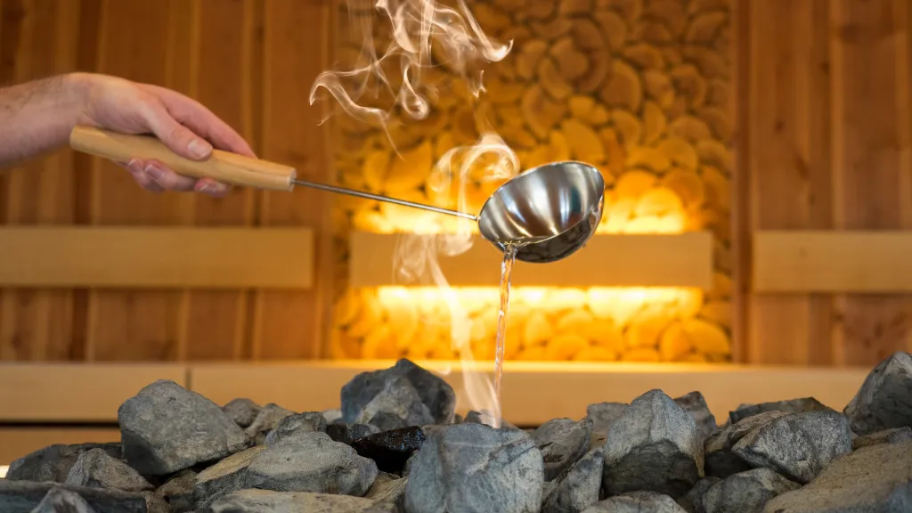 Eine Sauna, in der ein Aufguss durchgeführt wird, mit dampfender Luft und entspannender Atmosphäre.