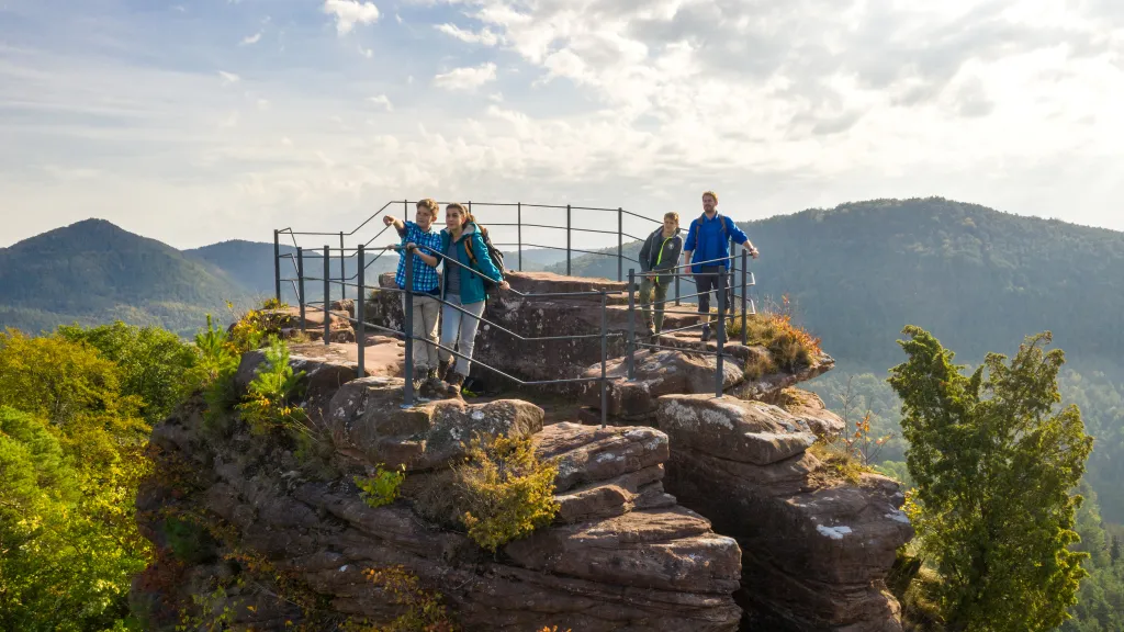 Eine Familie steht auf einem umzäunten Turm auf der Burg Altdahn 