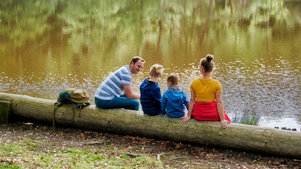 Familie sitzt am Weier