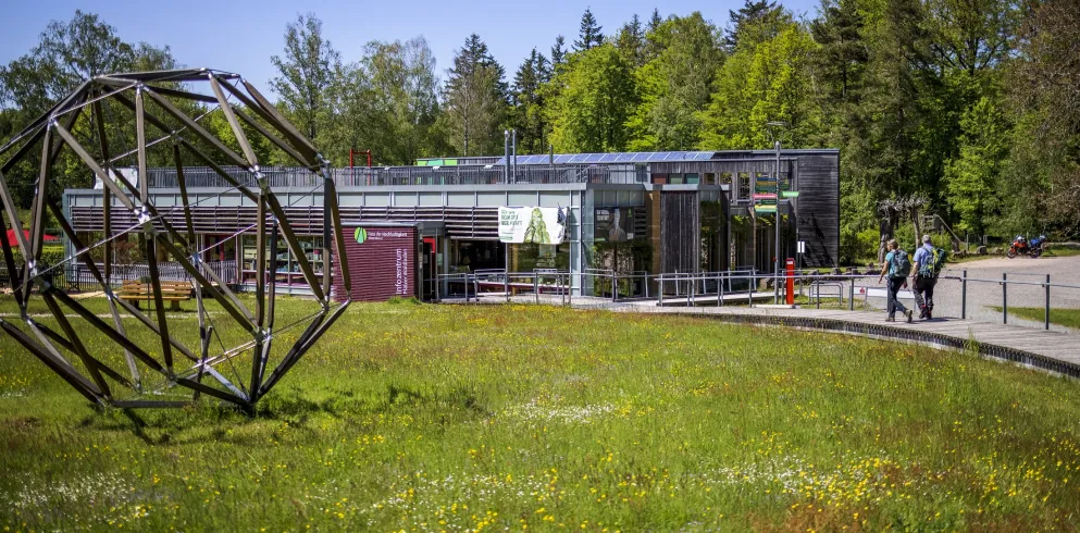 Haus der Nachhaltigkeit im Pfälzerwald im Sommer mit Wanderer