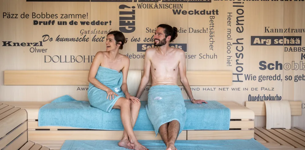 Zwei Personen sitzen in der Babbelsauna im Salinarium Bad Dürkheim Therme und unterhalten sich.