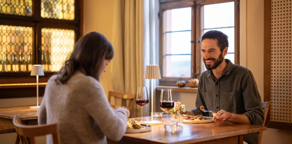 Zwei Personen sitzen an einem Tisch im Restaurant und genießen ein pfälzisches Gericht.
