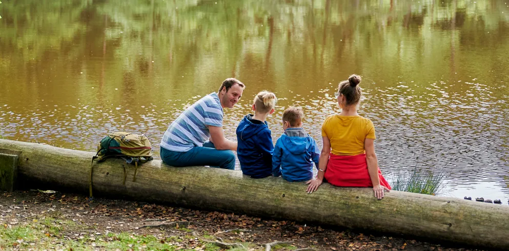 Familie sitzt am Weier