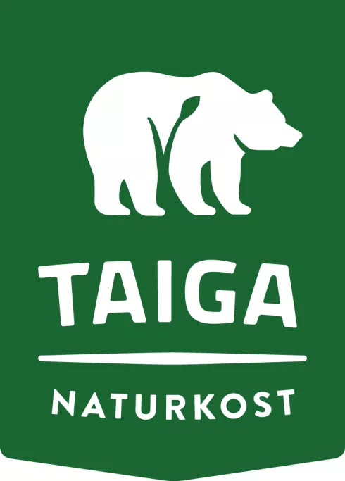 Weißer Eisbär und Schriftzug Taiga Naturkost auf grünem Grund