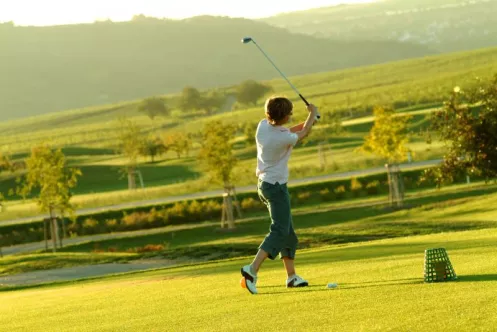 Ein Golfspieler beim Abschlag auf dem Grün