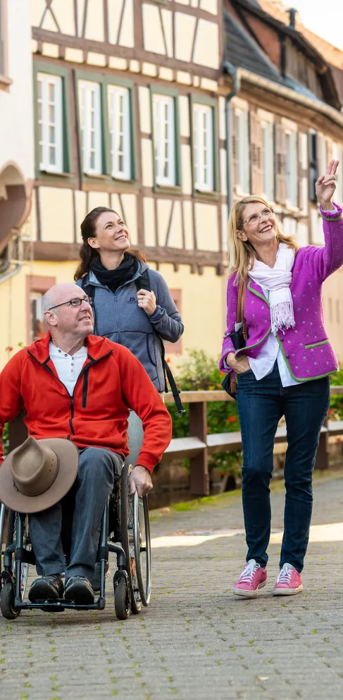 Menschen auf einer Gästeführung in einer Innenstadt mit Fachwerkhäusern.