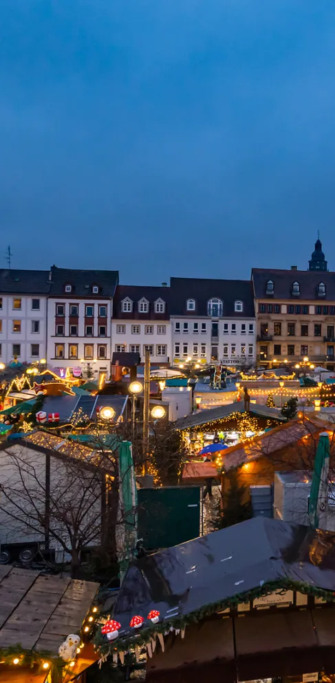 Der Rathausplatz in Landau mit Weihnachtsmarkt-Buden am Abends.