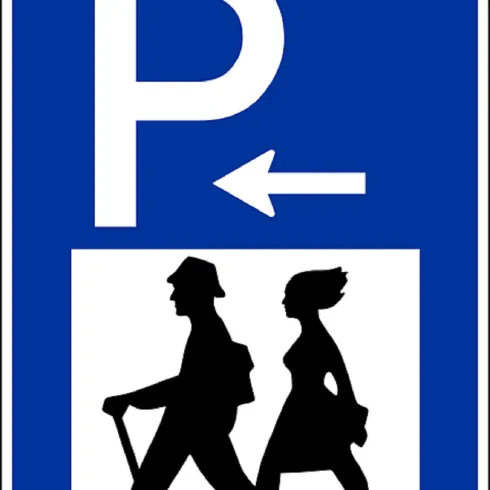 Ein Schild, das auf einen Parkplatz hinweist. Es zeigt zwei Personen, die zu Fuß gehen.