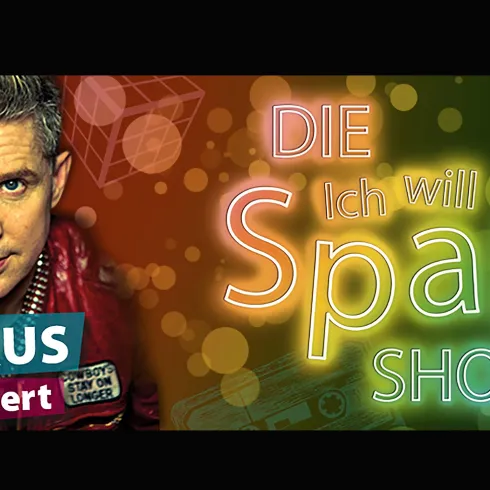 Ein Mann mit blonden Haaren trägt eine rote Jacke und lächelt. Im Hintergrund stehen bunte Texte mit dem Titel "Ich will Spaß!" und "SHOW".
