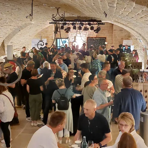 Ein belebter Veranstaltungsraum mit vielen Menschen, die sich unterhalten und feiern. Die Atmosphäre ist lebhaft und freundlich.