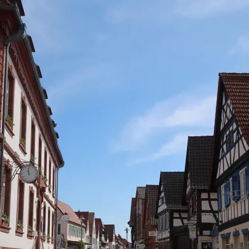 Eine ruhige Straße mit traditionellen Fachwerkhäusern und blauem Himmel. Die Architektur spiegelt den Charme einer deutschen Kleinstadt wider.
