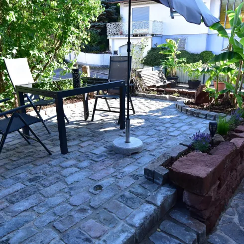 Ein schöner Innenhof mit einem Steingarten und einer gemütlichen Sitzgruppe. Der Platz ist ideal für entspannte Stunden im Freien.