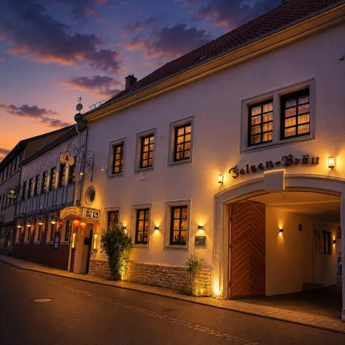 Ein charmantes Gebäude mit warmem Licht, das in der Abenddämmerung strahlt. Die Straße ist ruhig und von sanften Wolken am Himmel umgeben.