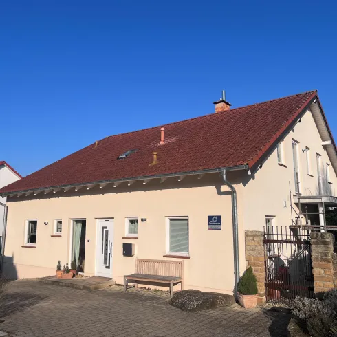 Ein modernes Wohnhaus mit einladendem Eingang mit einer Bank und Pflanzen.