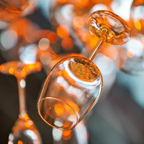 Schwebende Weingläser, die in warmem Licht leuchten. Eine kreative und elegante Dekoration.