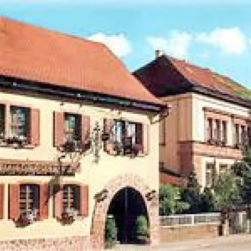 Ein charmantes Gebäude mit roten Dächern und blühenden Fenstern. Die Architektur ist typisch für eine deutsche Stadt.