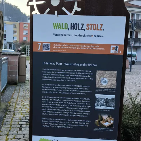 Ein Informationsschild über Wald und Holz. Es zeigt einen historischen Kontext und erläutert die Bedeutung dieser Ressourcen.