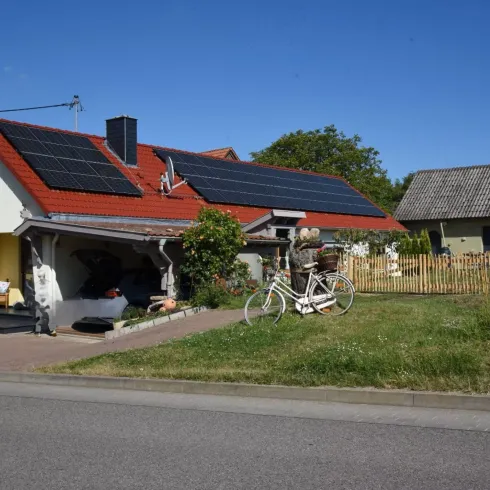 Ein hübsches Haus mit roten Ziegeln und Solarpanels auf dem Dach.