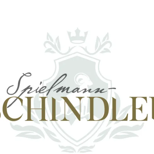 Das Bild zeigt ein stilisiertes Logo mit dem Namen "Spielmann-Schindler". Es ist elegant und hebt sich von einem dezenten Hintergrund ab.