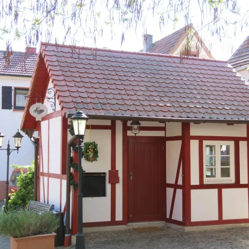 Historisches Backhaus mit Fachwerk.  Seitenansicht mit Eingangstür und nostalgiscehr Straßenlaterne daneben. 
